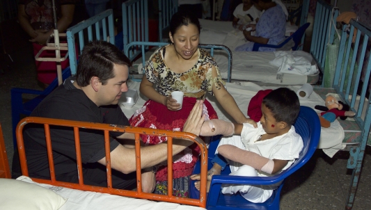 Dr. Ronan hi-fiving child in bandages