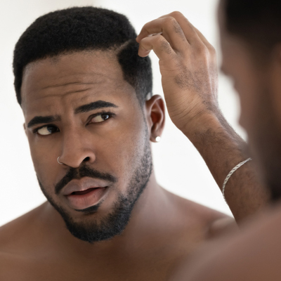 Black man looking himself in the mirror