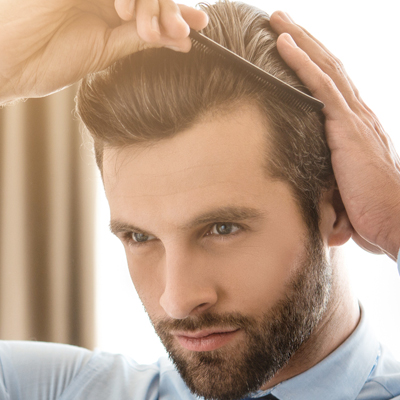 Man with beard combing full head of hair