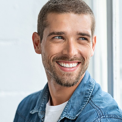 Confident young man looking away with big smile